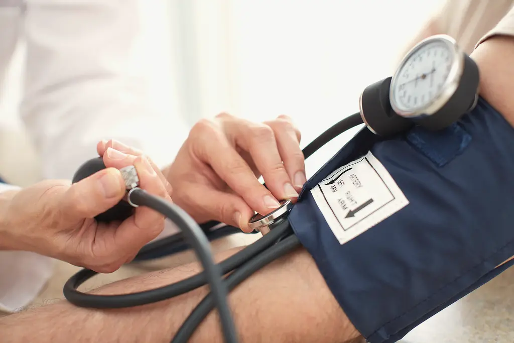 Profesional de salud controla la presión arterial de un paciente
